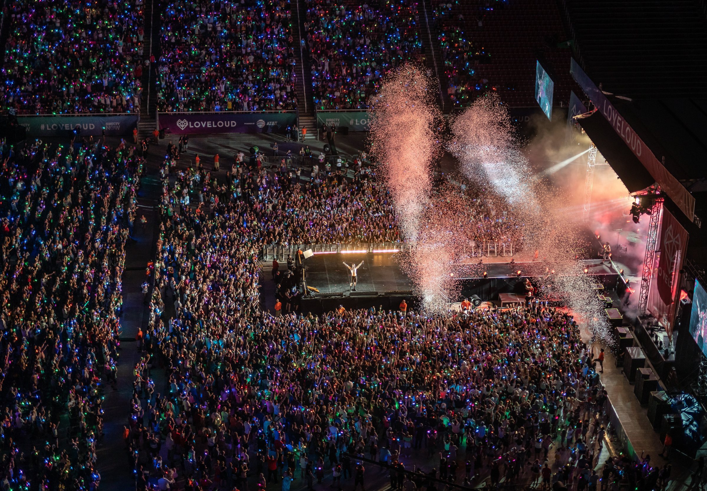 A LOVELOUD performer at center stage before a packed stadium crowd